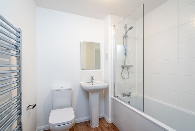 A bathroom with a toilet, sink, bathtub, and shower.