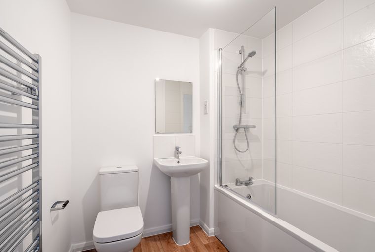 A bathroom with a toilet, sink, bathtub, and shower.