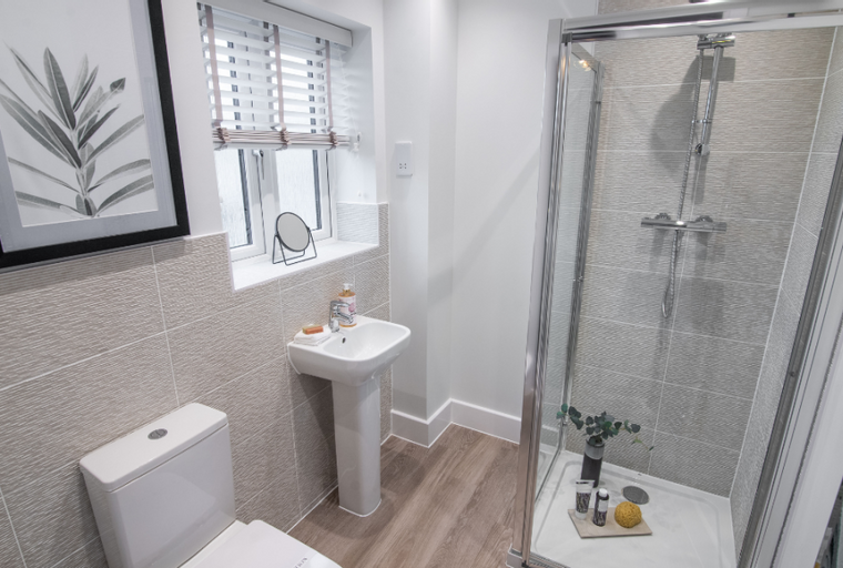 A bathroom with a toilet, sink, and shower stall.