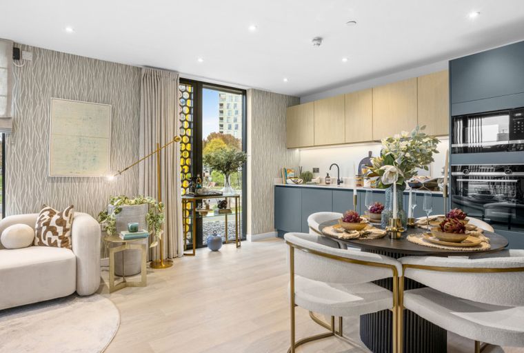 A living and dining area with a kitchen in a modern apartment.