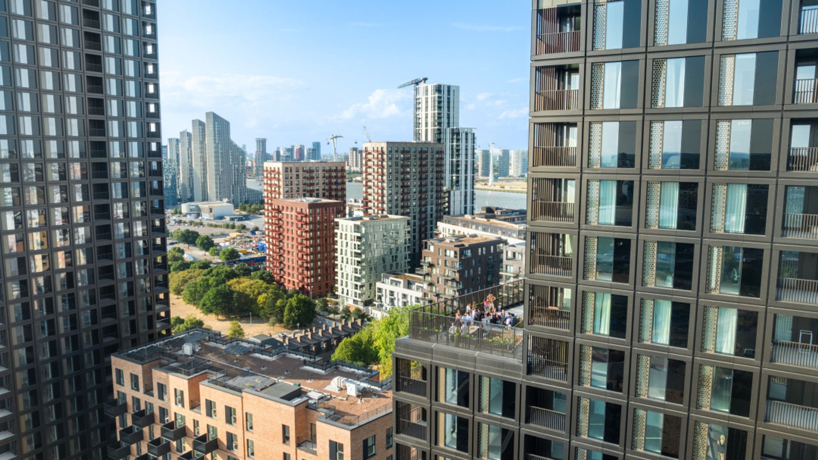 A cityscape with multiple modern apartment buildings under a clear blue sky.