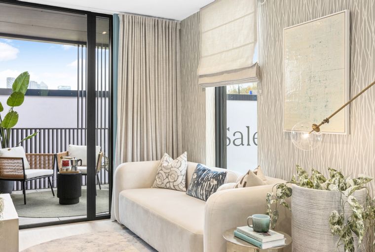 A living room with a sofa, balcony, and a floor lamp.