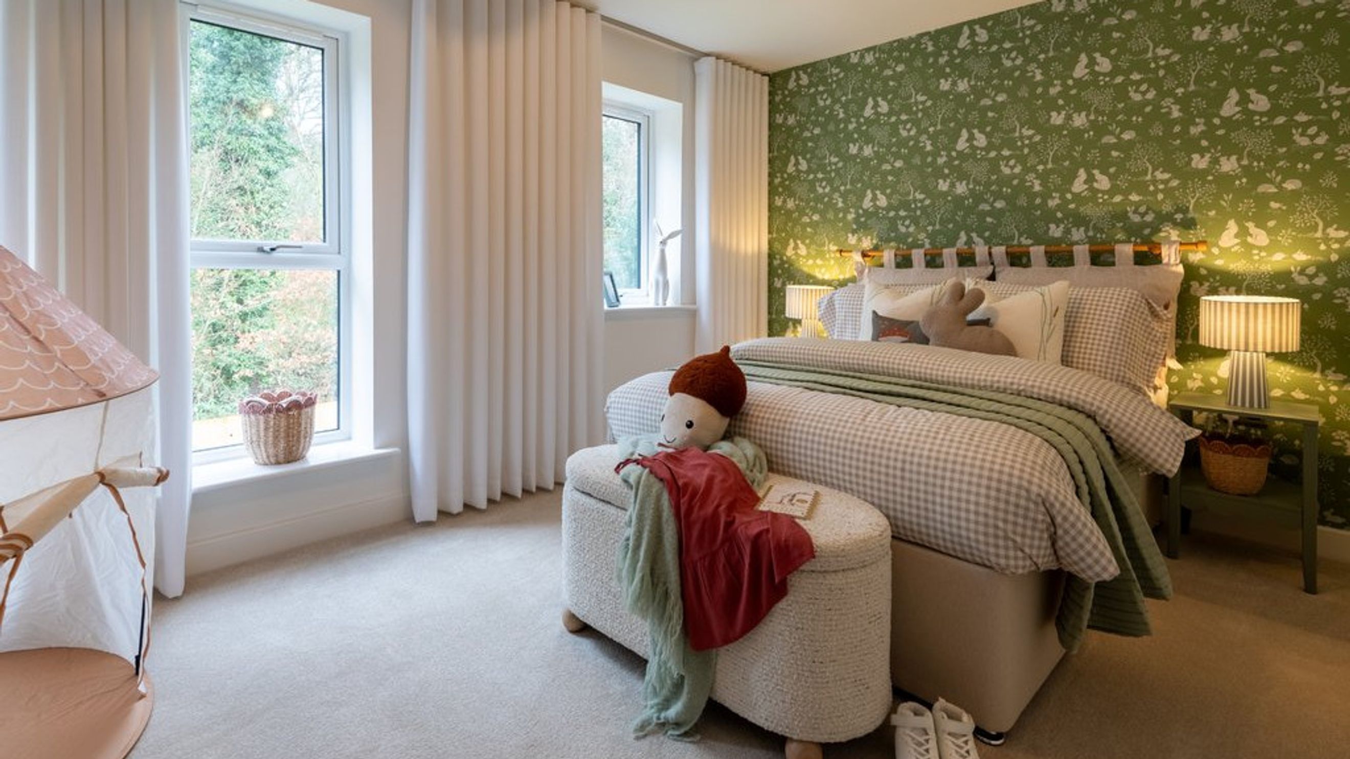 A bedroom with a bed, wallpaper, and windows.