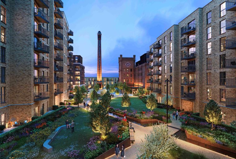 A courtyard garden with apartment buildings and a historic factory chimney.