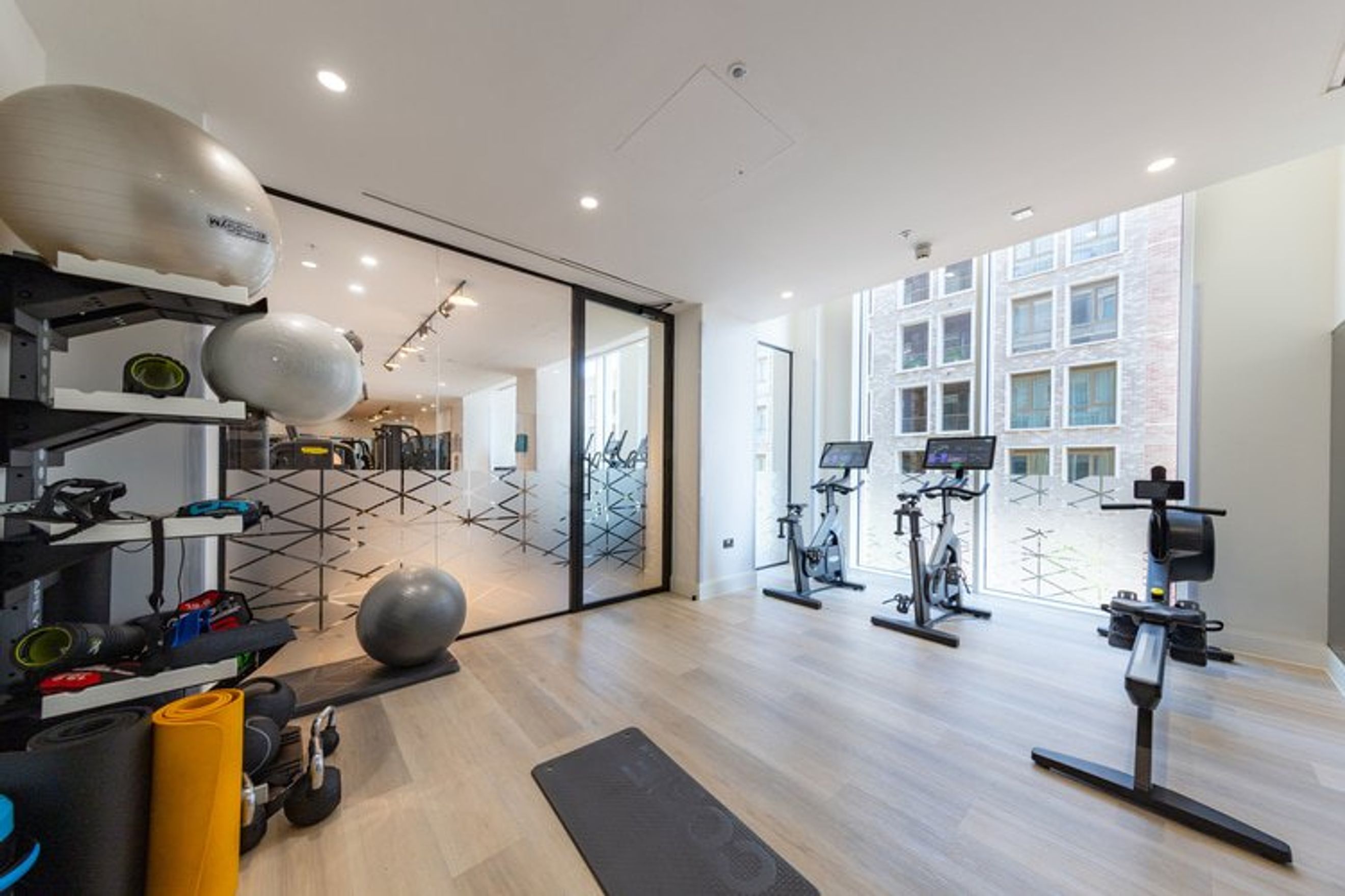 A gym with exercise bikes, a rowing machine, and exercise balls.