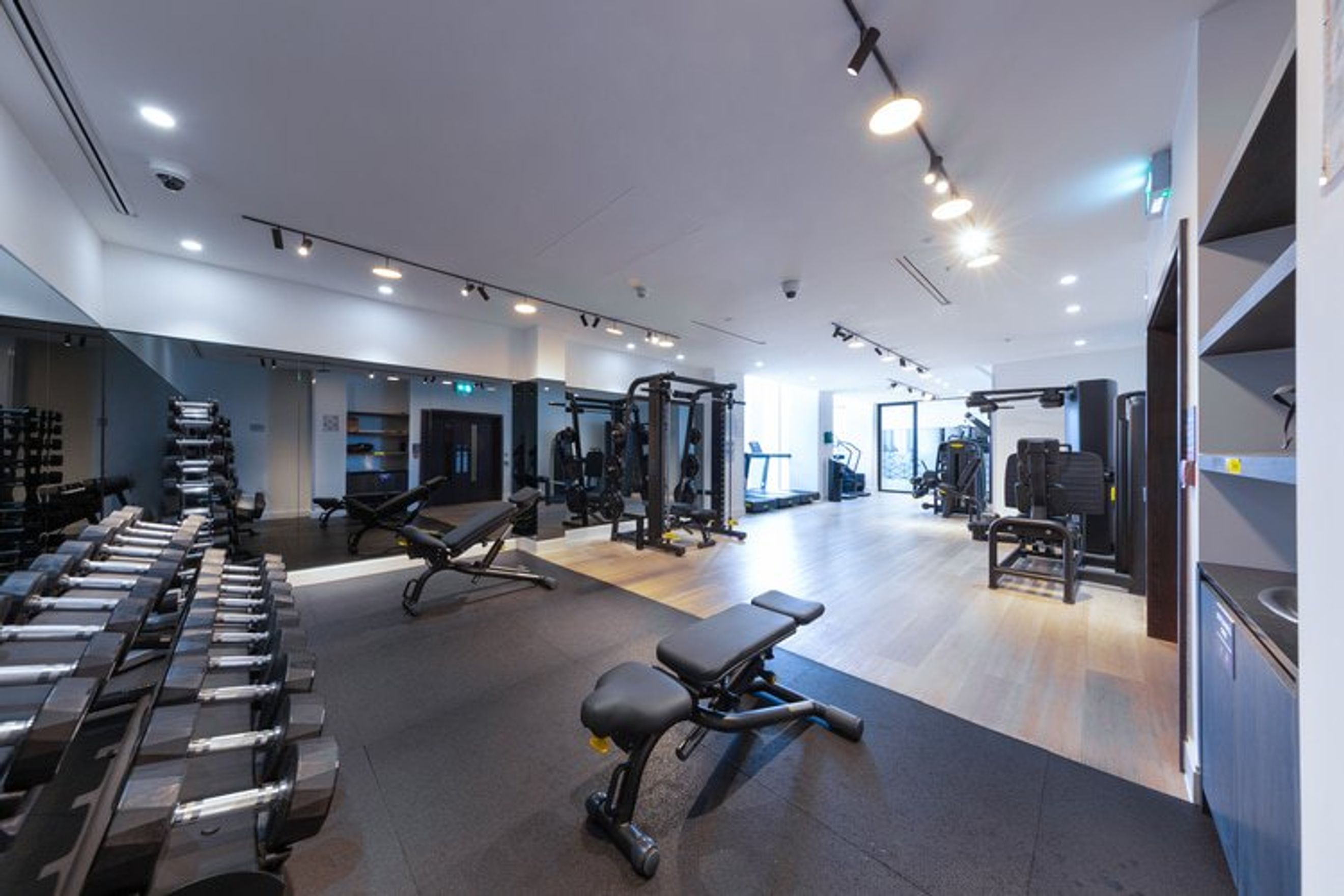 A gym with dumbbells, weight machines, and treadmills.
