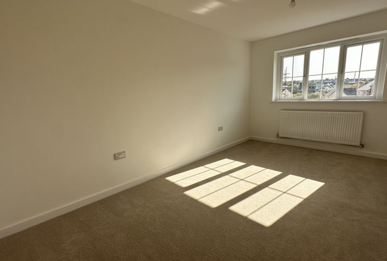 A bedroom with a window and a radiator.