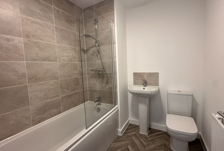 A bathroom with a bathtub, shower, sink, and toilet.