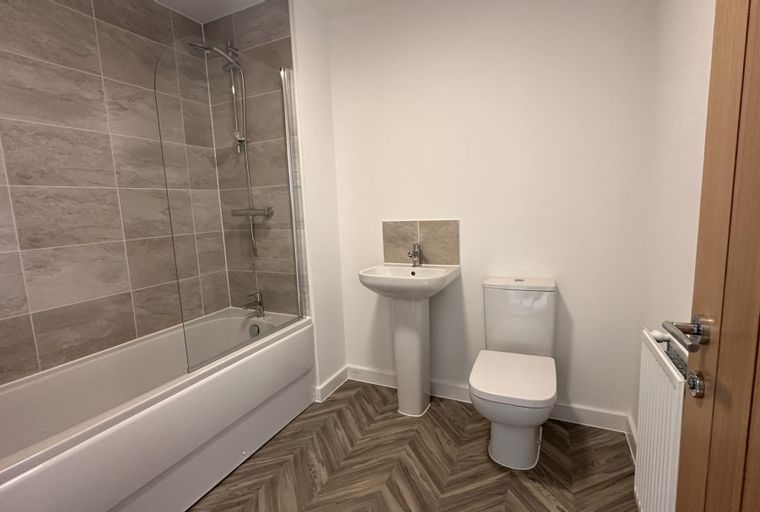 A bathroom with a bathtub, sink, and toilet.