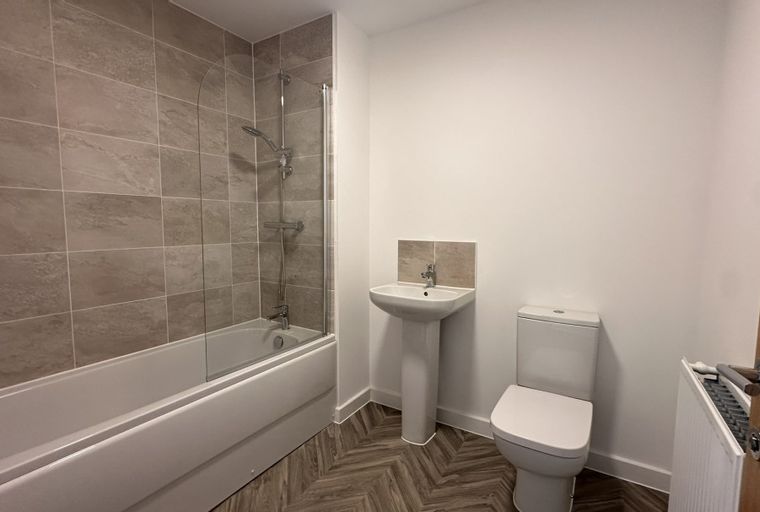 A bathroom with a bathtub, shower, sink, and toilet.
