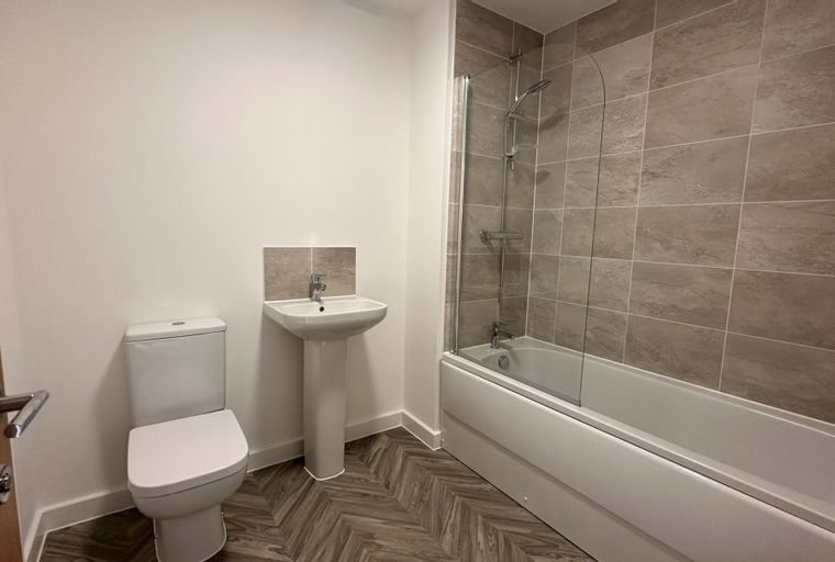 A bathroom with a toilet, a sink, and a bathtub with a shower.