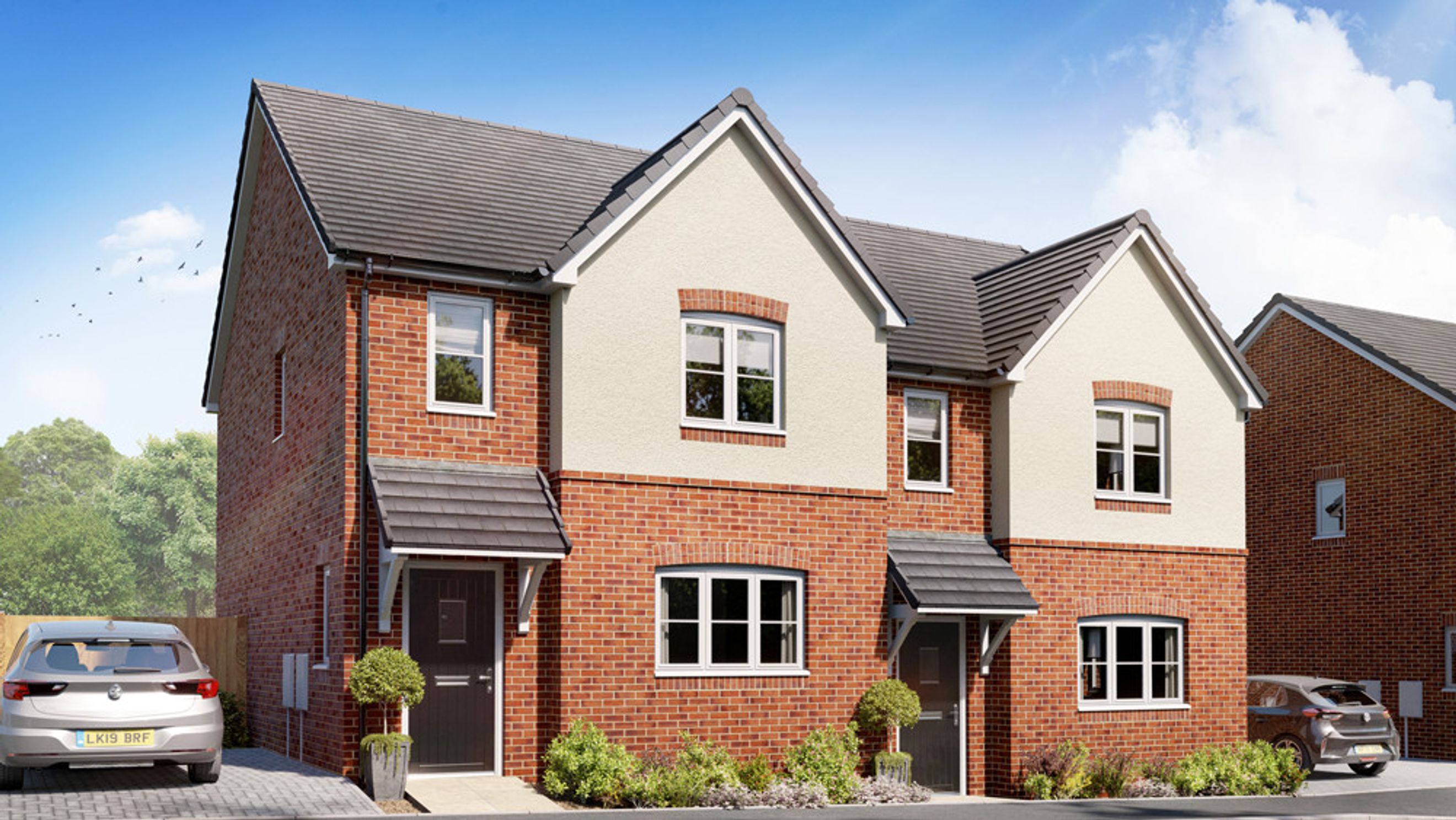 A new build semi-detached house with red brick and cream render exterior, featuring multiple windows and a grey tiled roof.