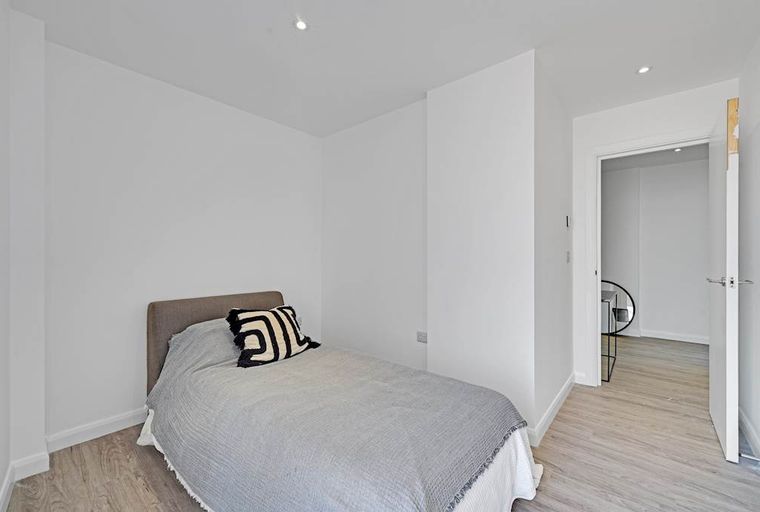 A bedroom with a bed, a pillow, and a doorway.