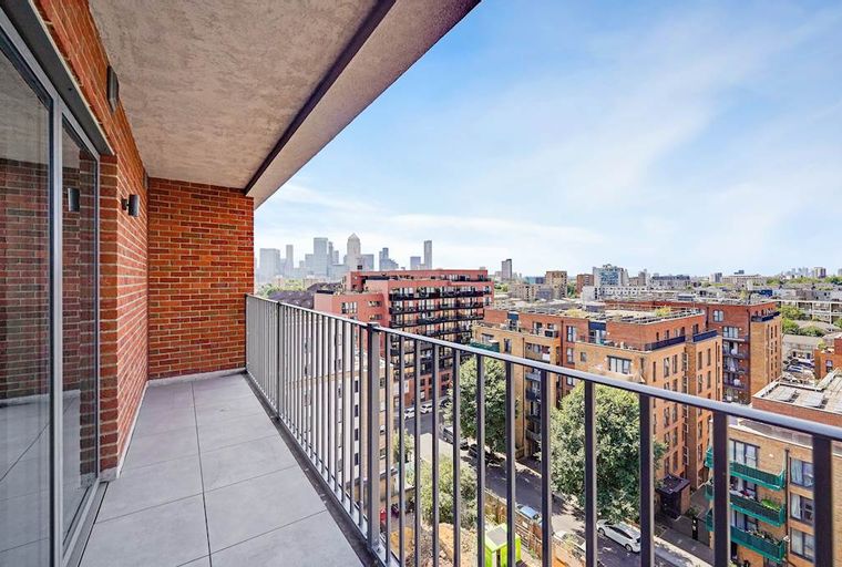 A balcony with a view of a cityscape and buildings.