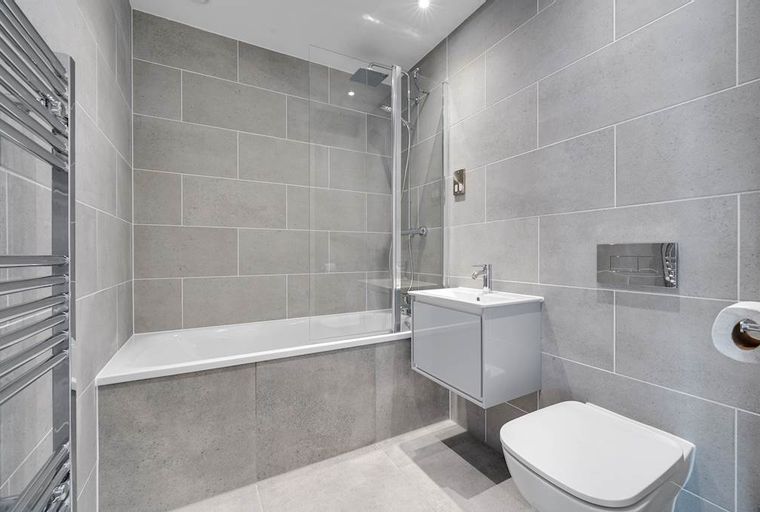 A modern bathroom with a bathtub, a vanity, and a toilet.