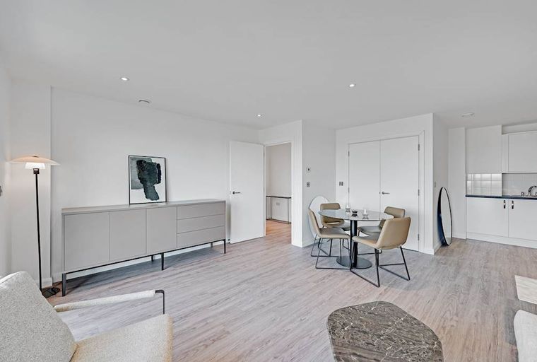 A living and dining area with a sideboard, dining table, and chairs.