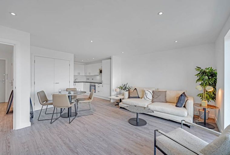A living room and dining area with a sofa, dining table, and chairs.