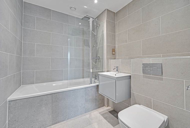 A bathroom with a bathtub, shower, sink, and toilet.