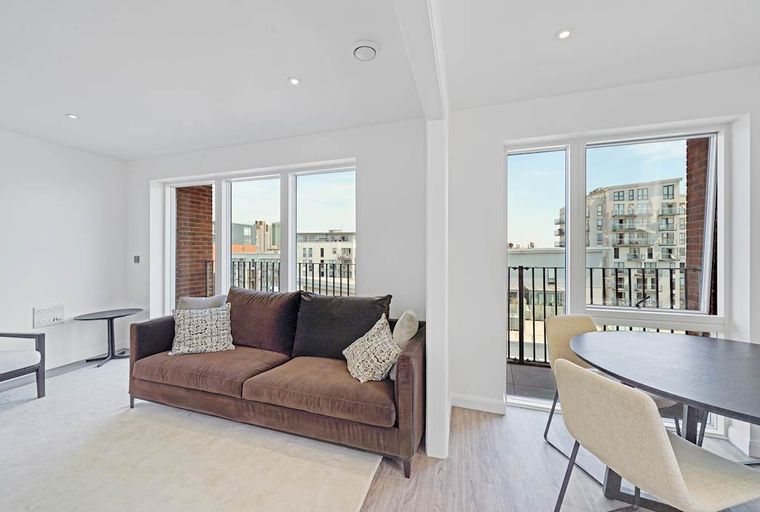 A living room with a sofa, coffee table, and dining table with chairs.