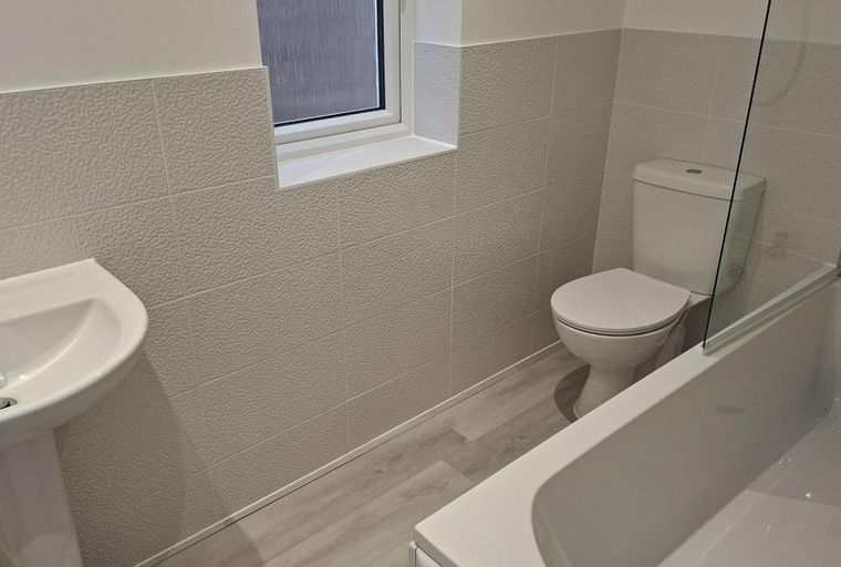 A bathroom with a sink, toilet, and bathtub.