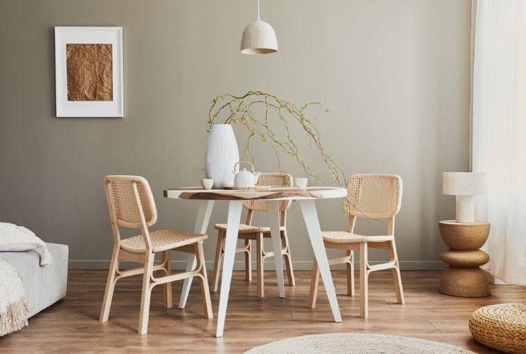 A dining table with four chairs, a vase, and a teapot.