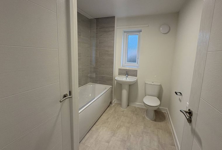 A bathroom with a bathtub, a sink, and a toilet.