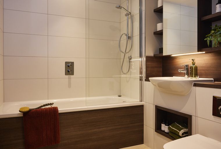 A bathroom with a bathtub, shower, and sink.