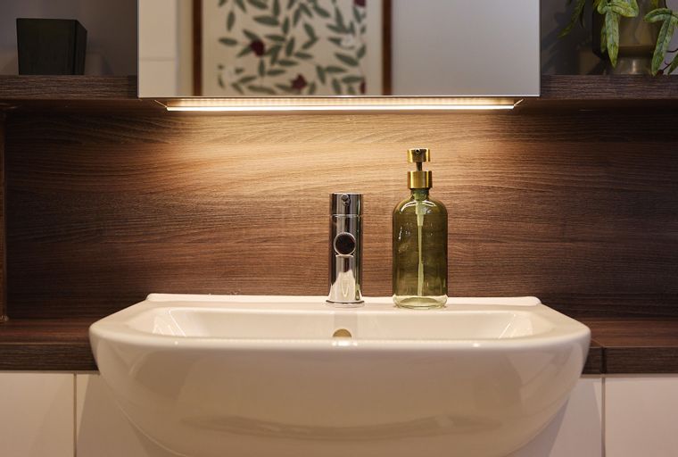 A bathroom sink with a faucet and a soap dispenser.