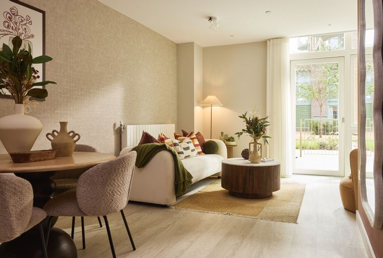 A living room with a sofa, coffee table, dining table, and chairs.