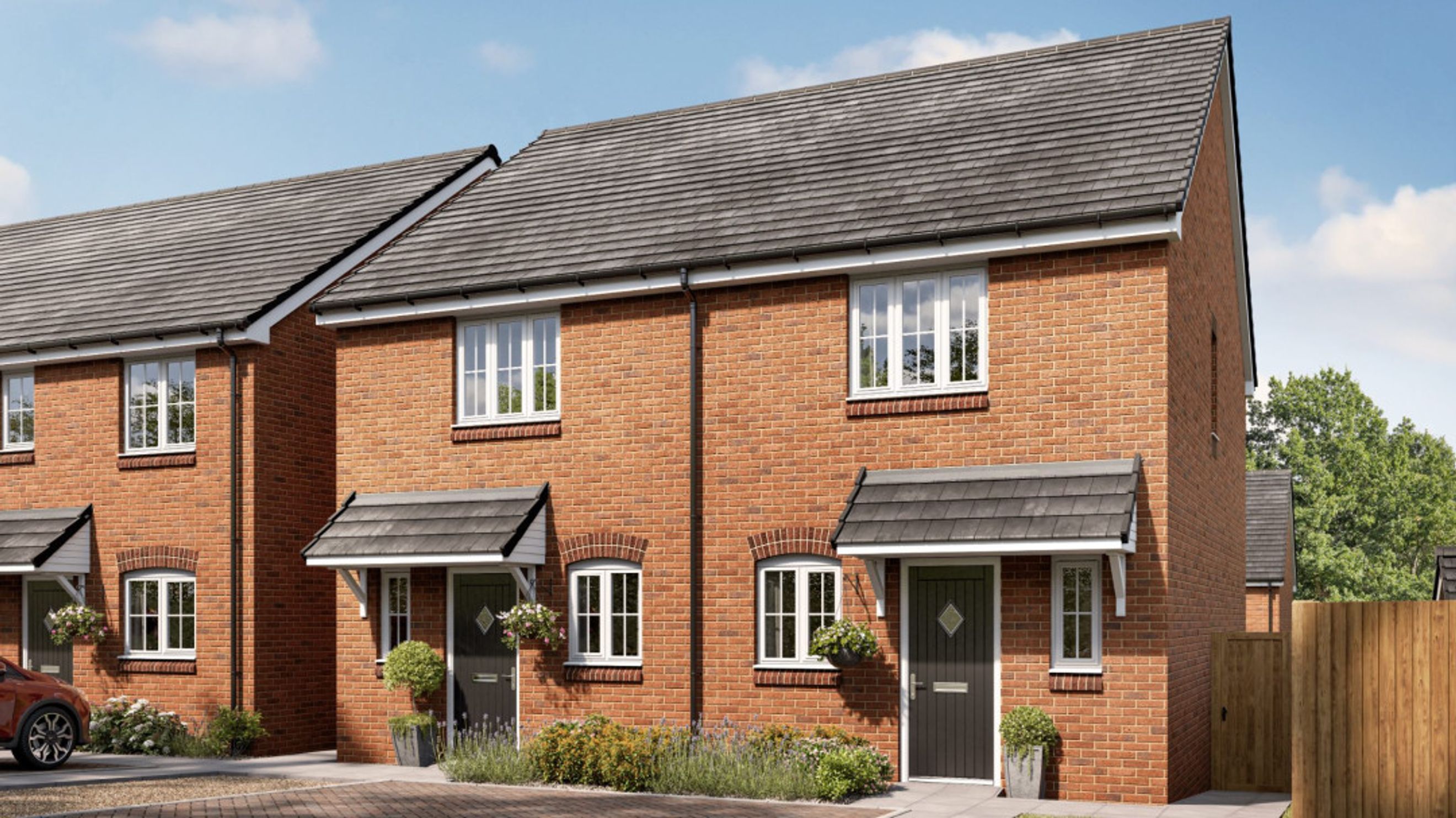 A row of brick townhouses with white-framed windows and front porches.