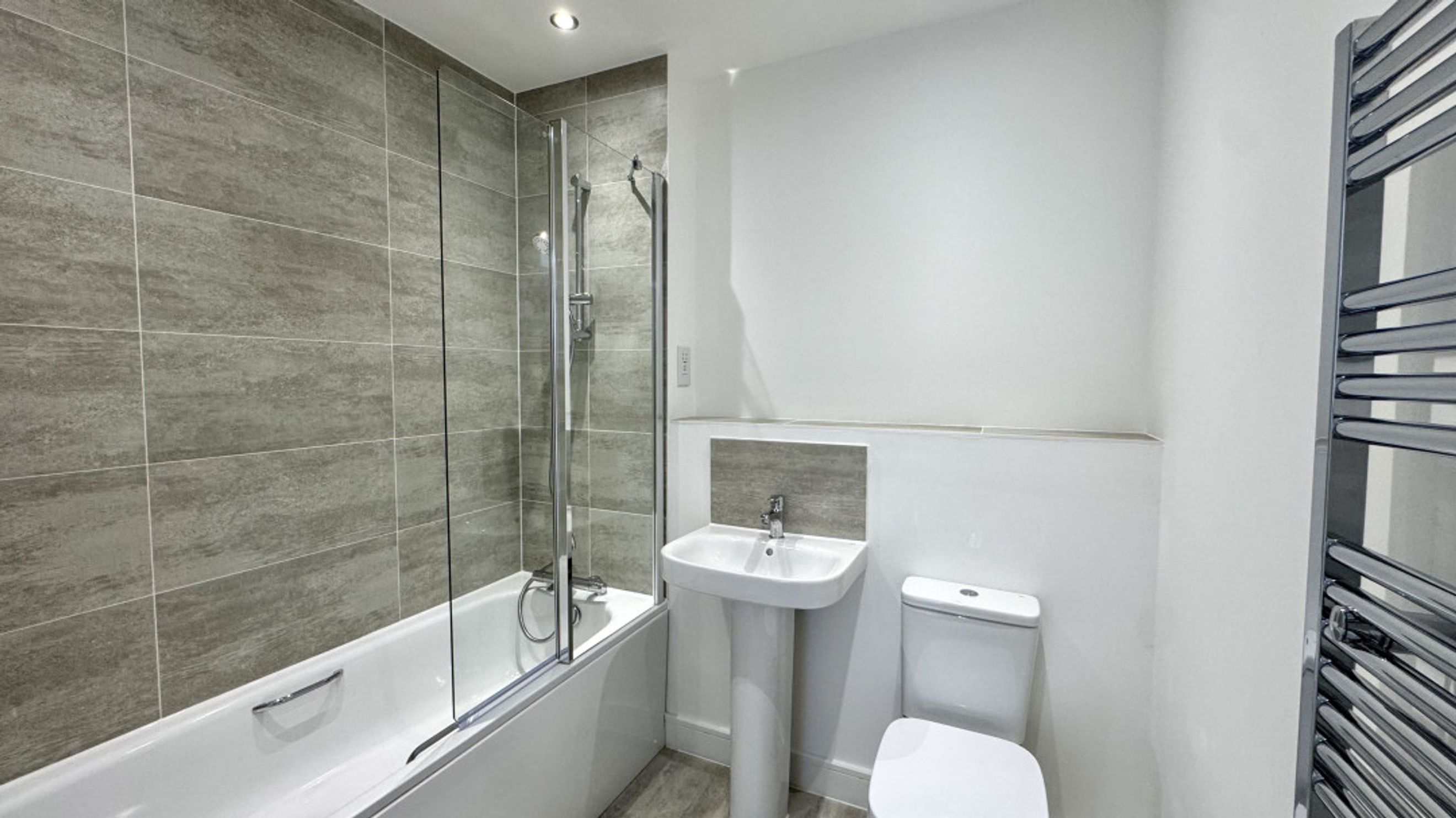A bathroom with a bathtub, sink, and toilet.