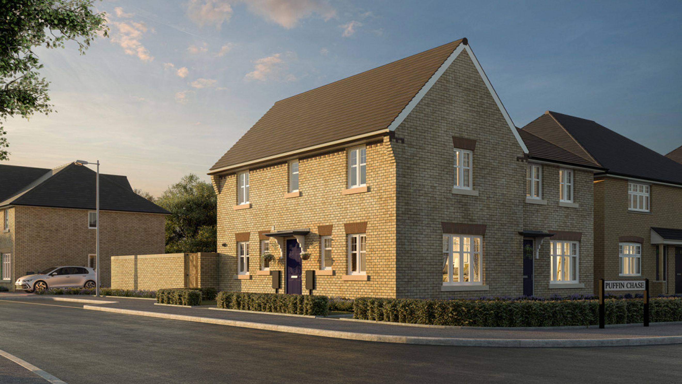 A street view of modern brick houses with manicured lawns and a street sign that reads 'PUFFIN CHASE'.