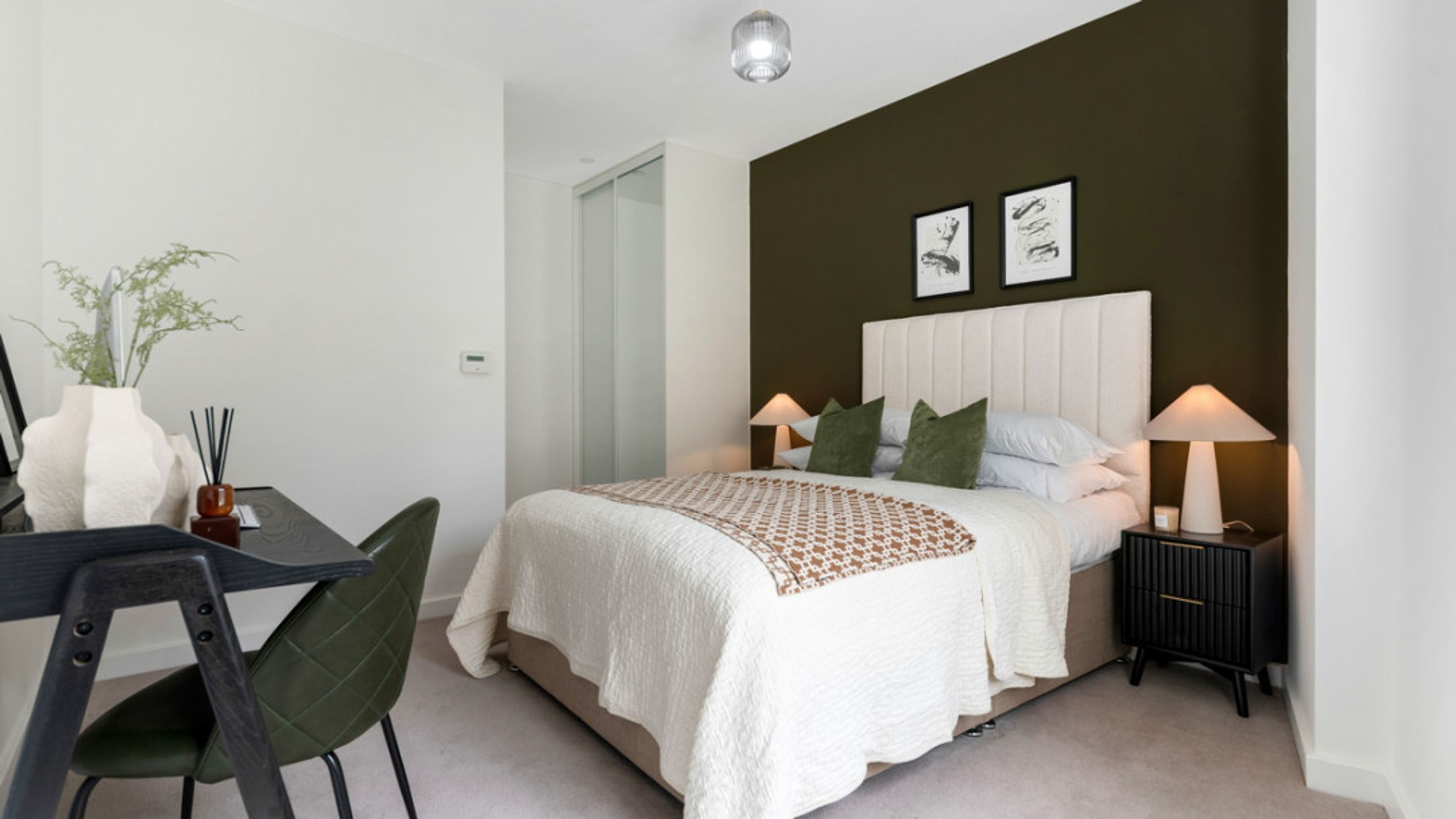 A bedroom with a bed, a desk, and a chair.