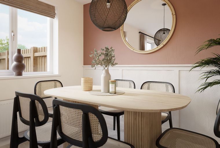A dining room with an oval table, cane-backed chairs, and a large window.