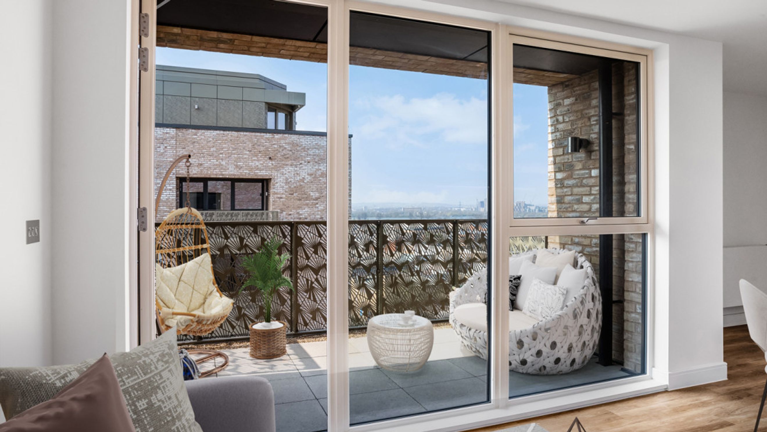 A balcony with hanging chairs, outdoor furniture, and a view of the city.