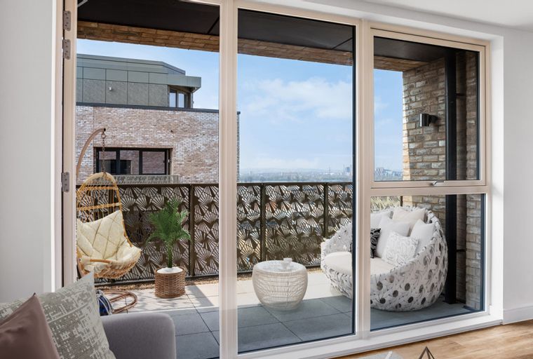 A balcony with hanging chairs, outdoor furniture, and a view of the city.