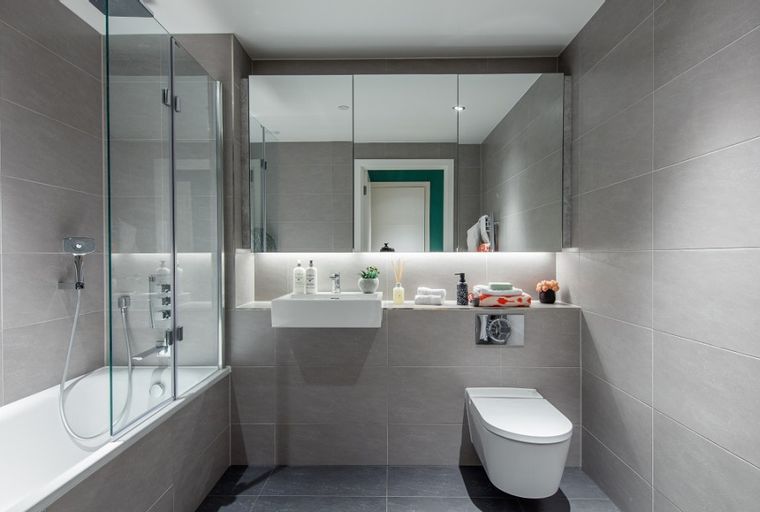 A modern bathroom with a bathtub, shower, sink, and toilet.