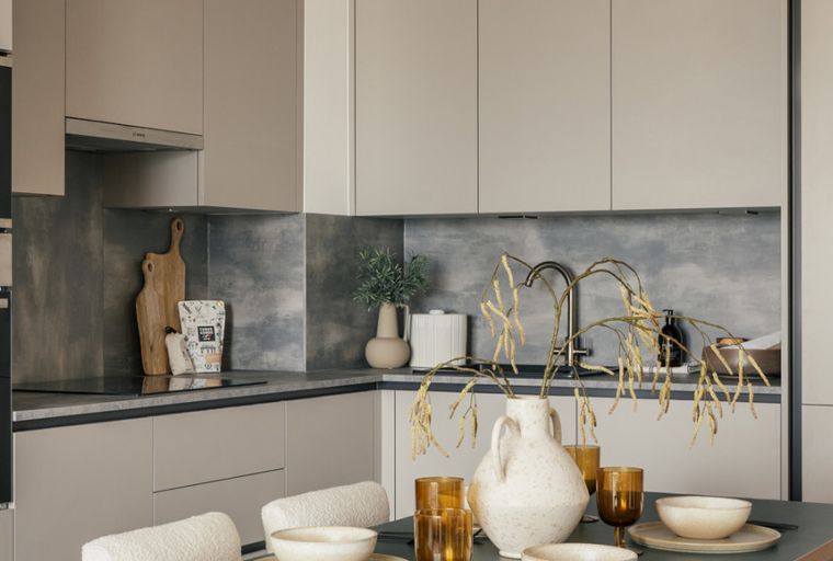 A modern kitchen with neutral cabinets, a grey backsplash, and Bosch appliances.