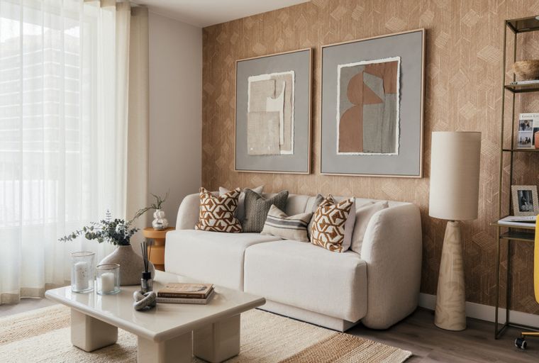 A living room with a white sofa, coffee table, floor lamp, and artwork.