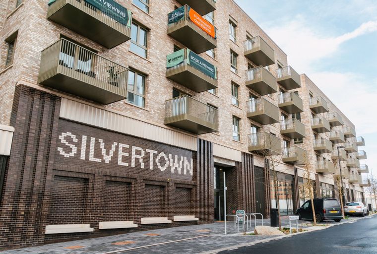 A modern apartment building with multiple balconies and the word 'SILVERTOWN' written on its brick facade.