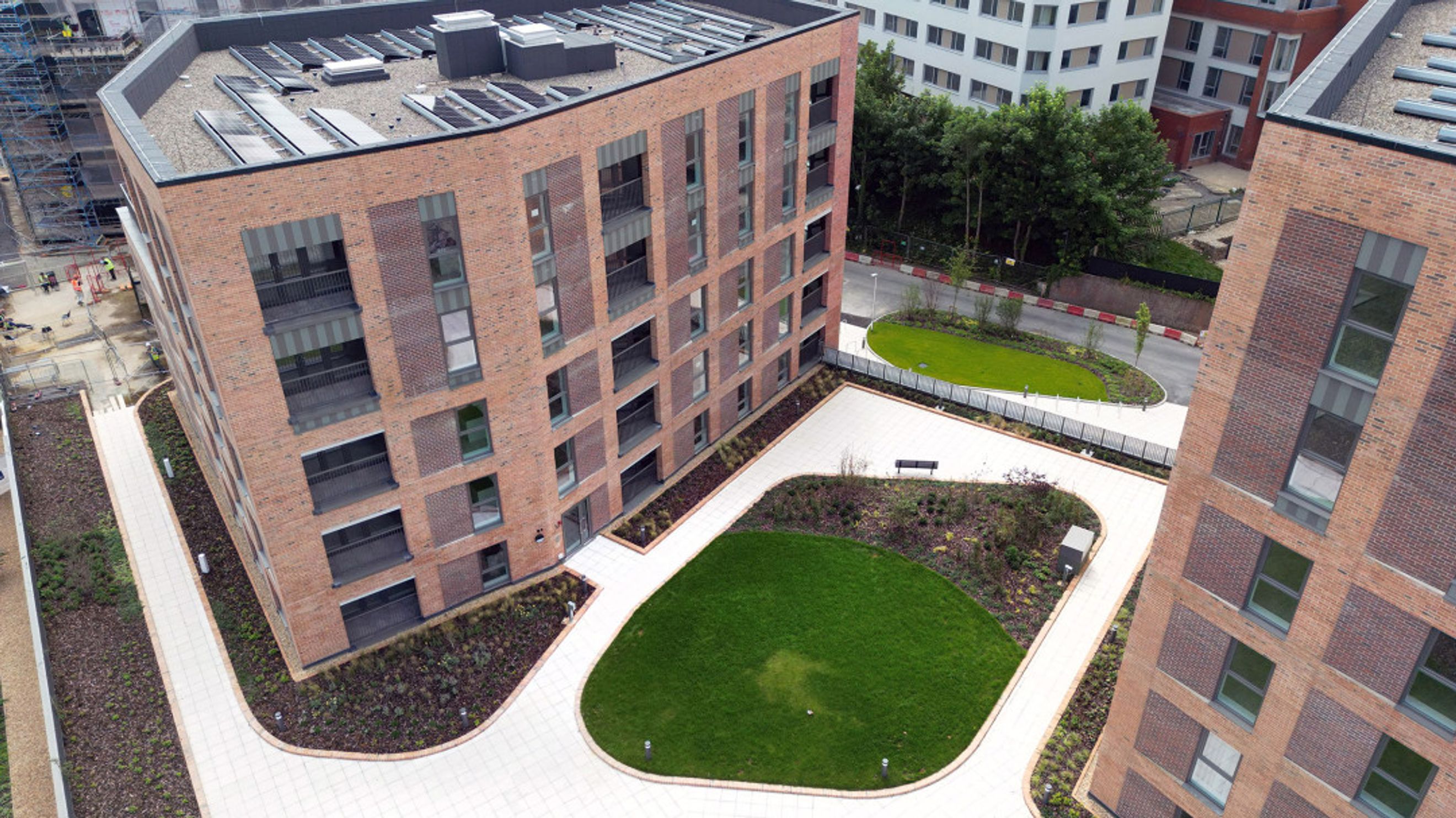 A view of modern brick apartment buildings with landscaped courtyards and walkways.