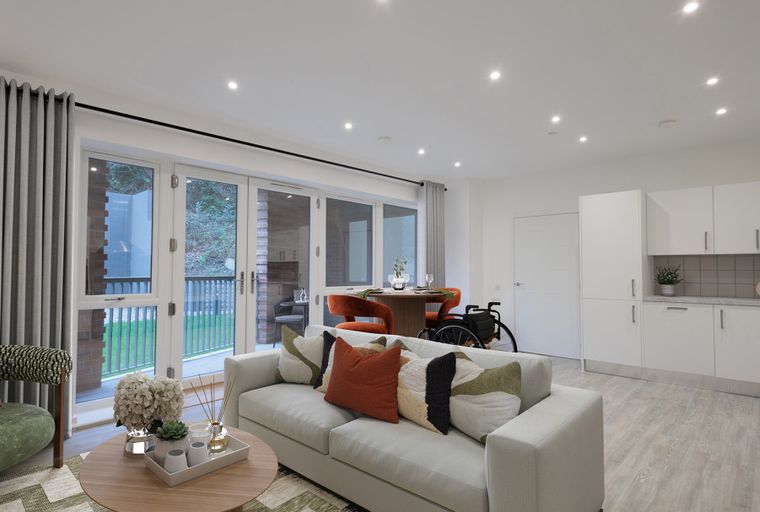 A living room and kitchen area with a sofa, dining table, chairs, and kitchen cabinets.