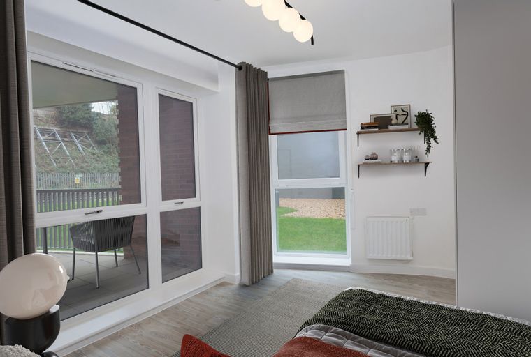 A bedroom with large windows, a balcony, and decorative shelves.