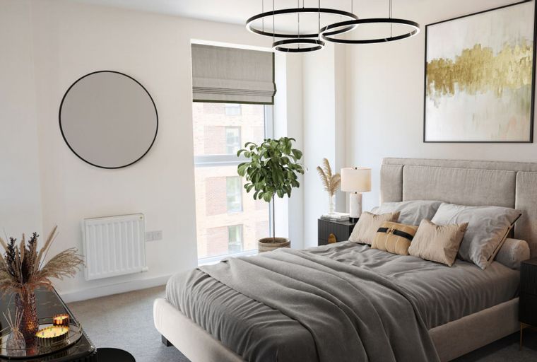 A bedroom with a bed, bedside tables, a mirror, and a window.