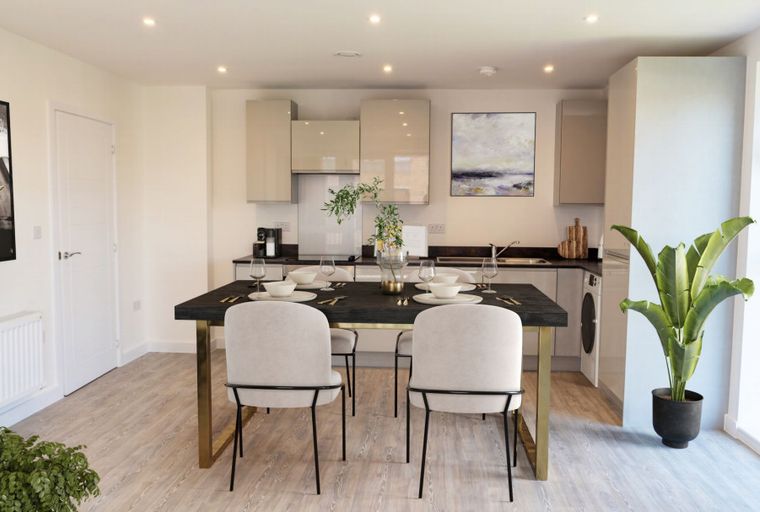 A dining area and kitchen with a table, chairs, cabinets, and a sink.