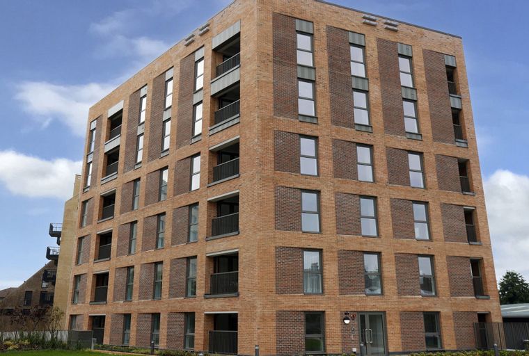 A modern brick apartment building with multiple floors and many windows.