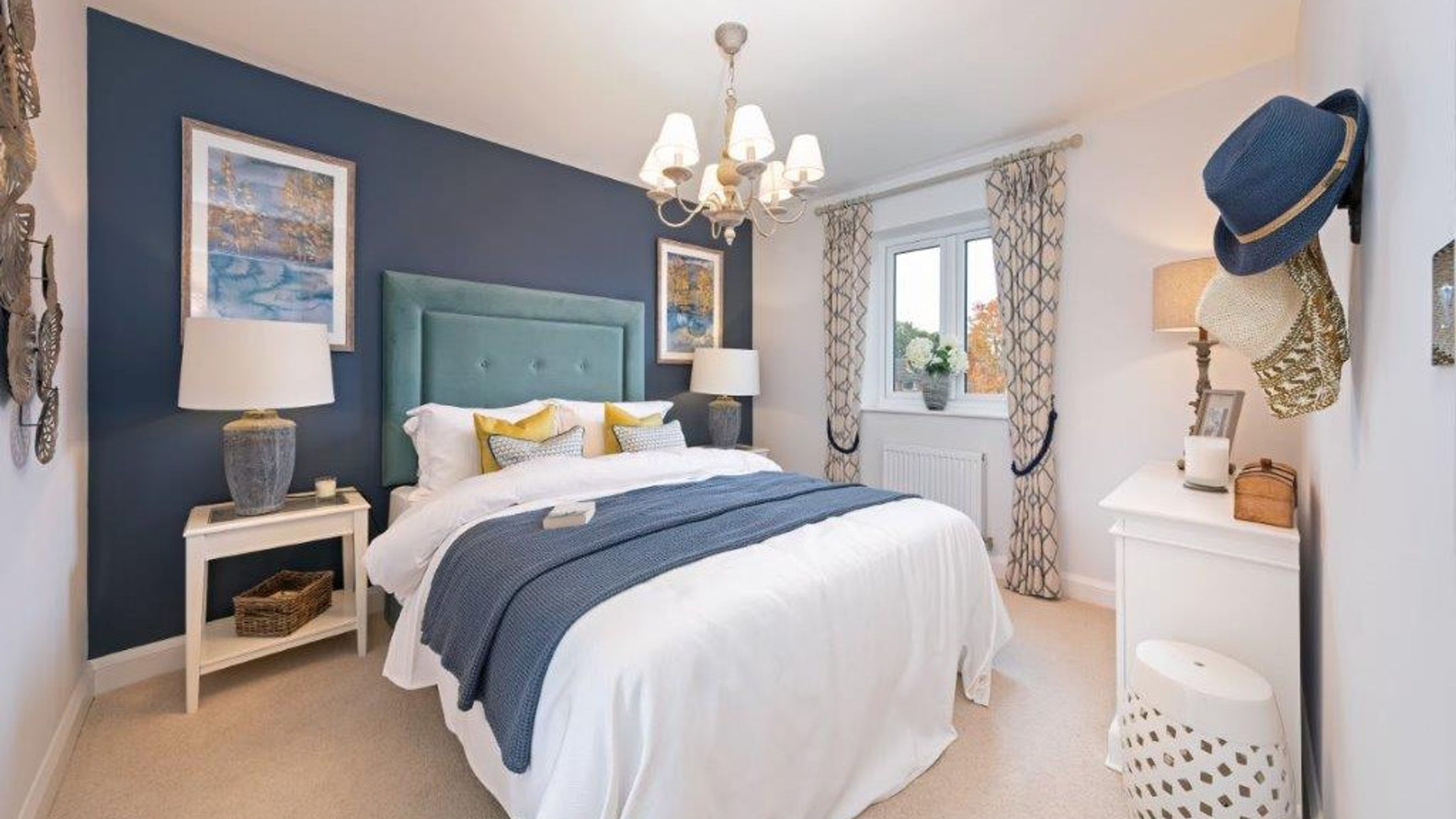 A bedroom with a bed, bedside tables, a dresser, and a window.