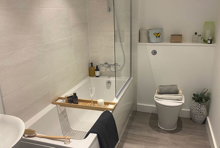 A bathroom with a bathtub, toilet, and sink.