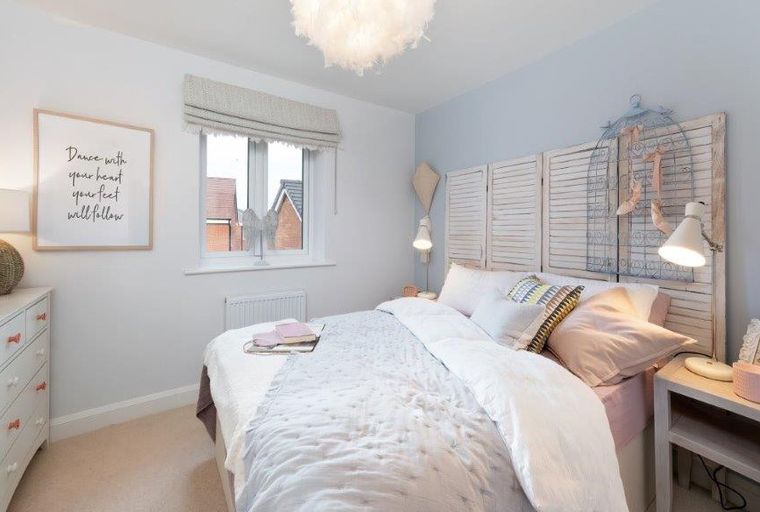A bedroom with a bed, dresser, and a framed picture on the wall.