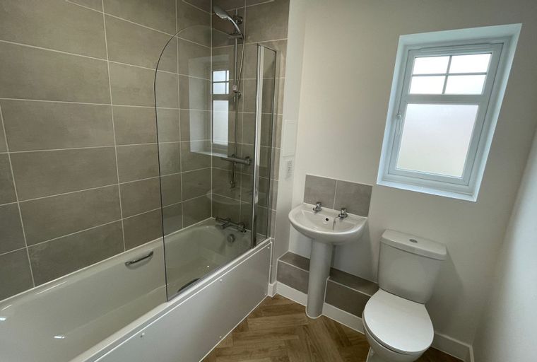 A bathroom with a bathtub, shower, sink, and toilet.
